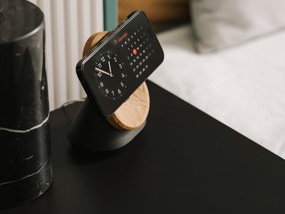 Minimalist wooden desk clock and green leaf on desk