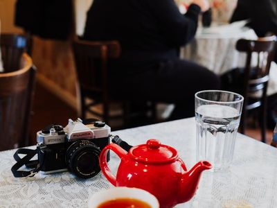 Person holding a cup of tea near a window
